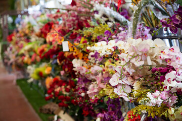 Colorful showcase of flower shop with large assortment of artificial flowers