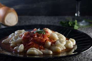 Pasta humeante elaborada con salsa. Concepto de comida en casera. Ñoquis de papa.  