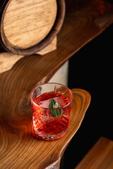 Classic sour cocktail with rum and fizz, beautiful red cocktail on an unusual wooden bar counter