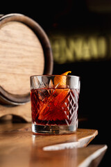 Close up of tum alcoholic cocktail  with a beautiful reflection on a bar counter, soft light, dark tempting atmosphere