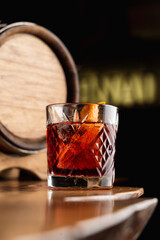 Close up of tum alcoholic cocktail  with a beautiful reflection on a bar counter, soft light, dark tempting atmosphere