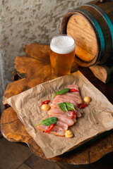 Fancy modern pub a tall glass of IPA light beer with gourmet raw chicken snack on a wooden bar counter