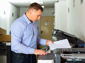 Office worker puts a stack of paper in the printer. High quality photo