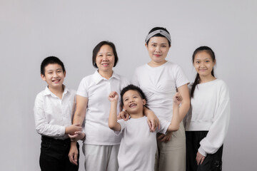Portrait of Grandmother and grandchild hugging, looking at camera and smiling, on gray background