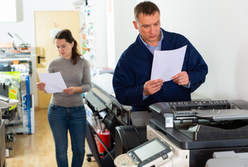 Printing company employees work on various printing machines. High quality photo