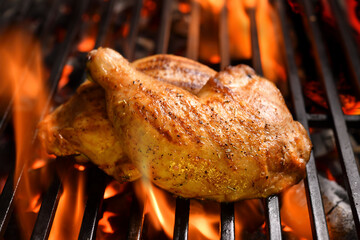 Grilled chicken thighs on the flaming grill