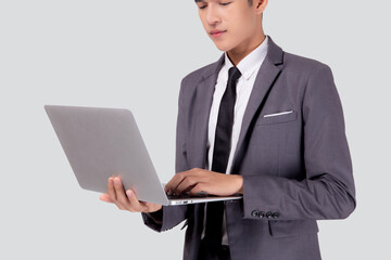 Young asian business man standing work on laptop computer to internet online isolated on white background, businessman confident and notebook, freelance with success, marketing and communication.
