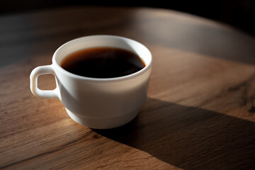 Close-up of ceramic coffee cup on wooden table.