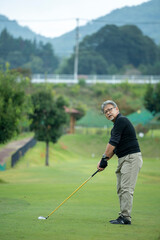 ゴルフを楽しむシニア男性