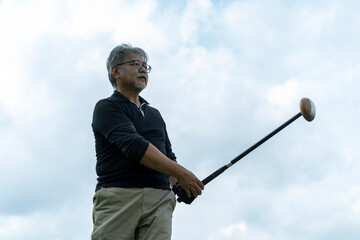 ゴルフを楽しむシニア男性