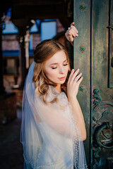 gentle bride in white dress stands by Beautiful black metal gates in retro style