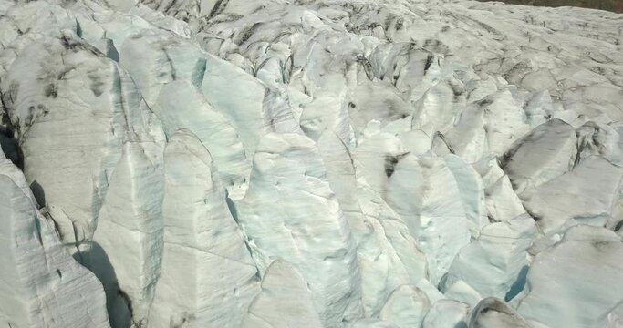
Aerial view over Glacier lagoon in Europe Fjallsárlón Iceland 
Ridges with black ash. Melting ice. Concept of global warming, February 2021
