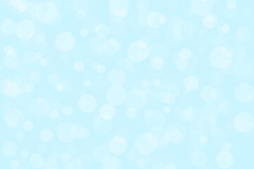 Abstract white bokeh with soft light blue background.  Snowfall in the winter and all celebration backgrounds concept.