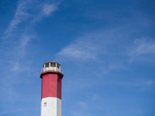 red and white lighthouse with blue sky