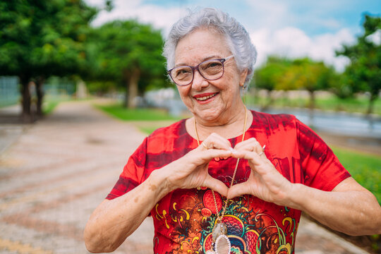 Joyful senior lady in glasses laughing heart with hands. Latin American woman. Brazilian elderly woman.