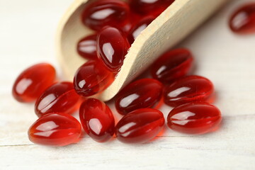 krill oil red gelatin capsules close-up.omega fatty acids.Natural supplements and vitamins.Red capsules with krill oil in a wooden scoop 