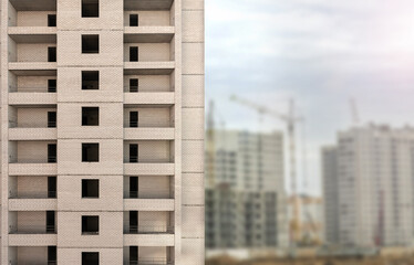 Brick house under construction on blurred construction site background. Multi-storey building with a place to write