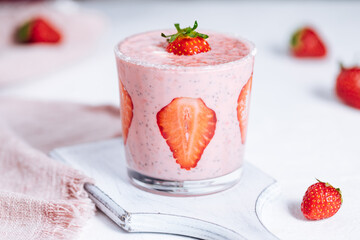 Strawberry and chia yoghurt served in glass on a bright background 