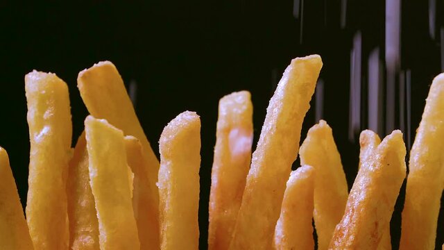French fries up close with elegante lighting and salt slowly falling 
