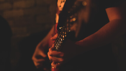 Close up of guitarist musician playing guitar on stage.