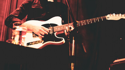 Close up of guitarist musician playing guitar on stage.