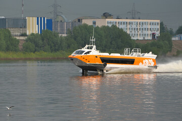 Fototapeta premium A hydrofoil boat goes along the river along the port city. High quality photo