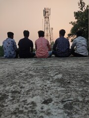 Group of happy friends stands with sun rice