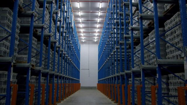 POV Of A Person Walking In Narrow Aisle  Of Warehouse With Pallet Racking System. - zoom in