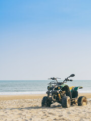 Vintage green ATV on the sandy beach. Quad ATV all terrain vehicle parked on beach, Motor bikes...