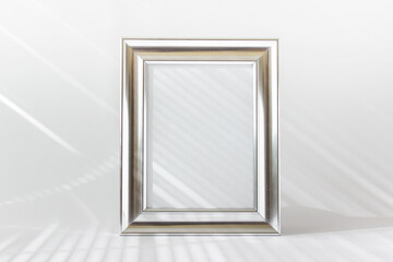 Mockup template with silver metallic wide frame with blan kspace and light rays on white background.