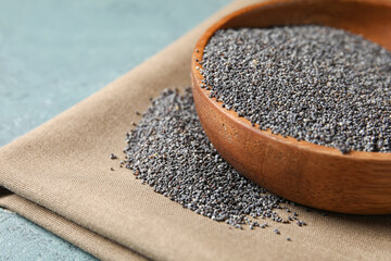 Plate with poppy seeds on color background