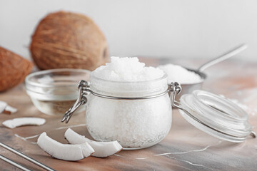 Jar of natural coconut scrub and ingredients on grunge background, closeup