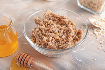 Bowl of natural scrub and ingredients on grunge background, closeup