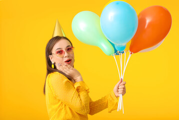 Beautiful woman with balloons on color background