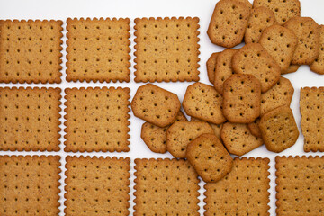 Pattern and pile of wholegrain spicy crackers. Isolated on a white background.