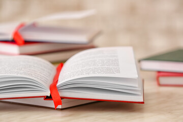 Open book with bookmark on light background, closeup