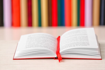 Open book with bookmark on color background, closeup