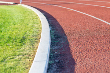 Part Red plastic track in the outdoor track and field stadium.Close-up.