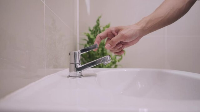 Concept save water and resuce energy. man use hand closes water tap. Turn off the water after not use for saves energy and save money reduces global warming.