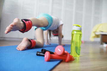 Sport and healthy lifestyle.Child playing sports at home. Yoga mat dumbbell and jump rope. Sports background home exercises concept.