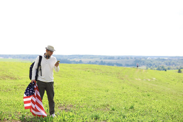 Man waving American flag standing in grass farm agricultural field , holidays, patriotism, pride, freedom, political parties, immigrant