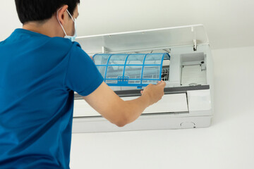 Asian man cleaning air conditioner filter
