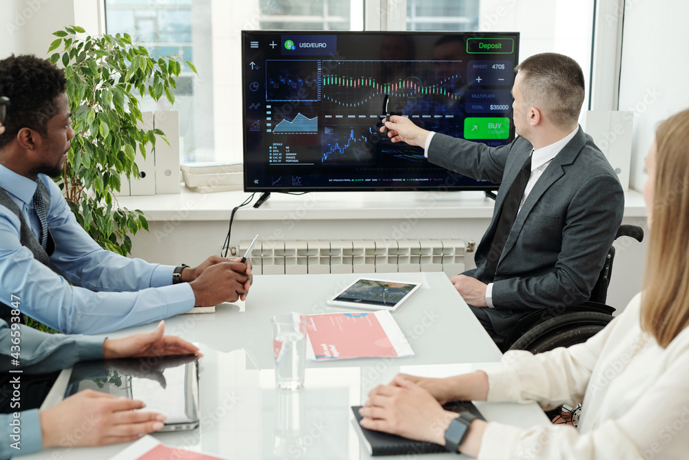 Poster Businessman pointing at display of computer while showing data
