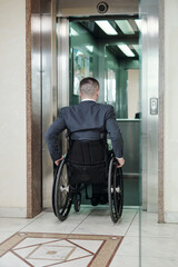 Back view of disabled businessman entering elevator inside modern office building © pressmaster