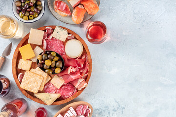 Charcuterie and cheese platter, overhead flat lay shot with copy space. Italian antipasti or Spanish tapas, shot from above with wine, olives, and sandwiches. Gourmet appetizers