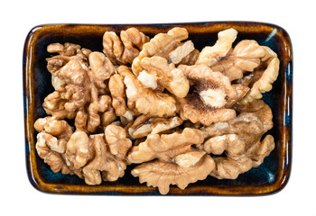 top view of peeled walnuts in bowl cutout on white