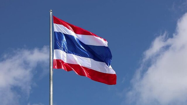 The Thai flag waved slowly in the wind. The symbol of Thai fluttering beautifully on a blue sky background.