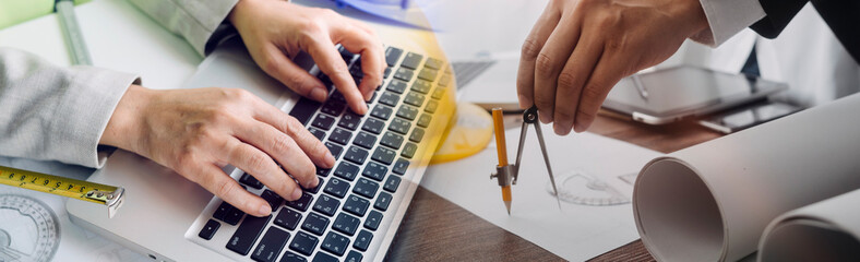 Construction engineer working at blueprint to build large commercial buildings in office. Engineering tools and construction concept.