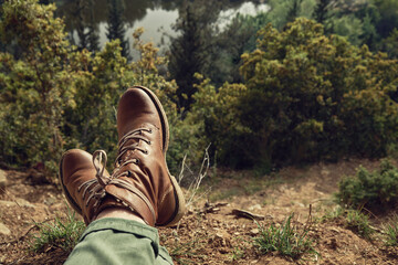 Girl in hiking boots relaxing outdoor at the forest