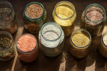 cereals in glass jars. legumes, peas, buckwheat, rice, burlap, barley, lentils, red lentils.